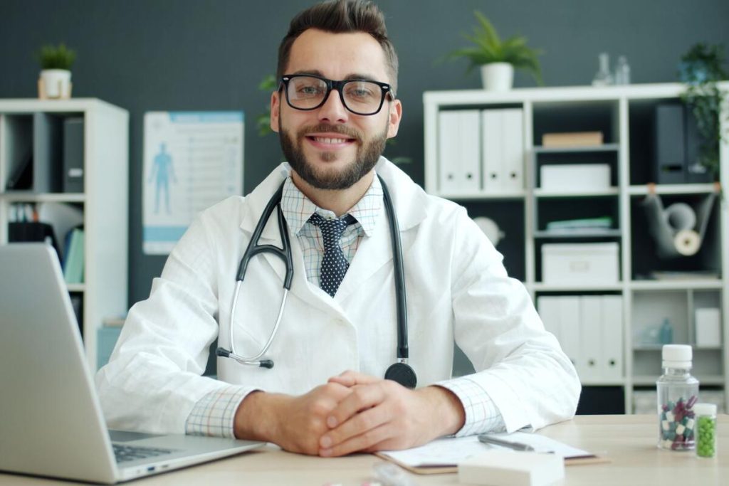 doctor using laptop computer in bright modern clinic office