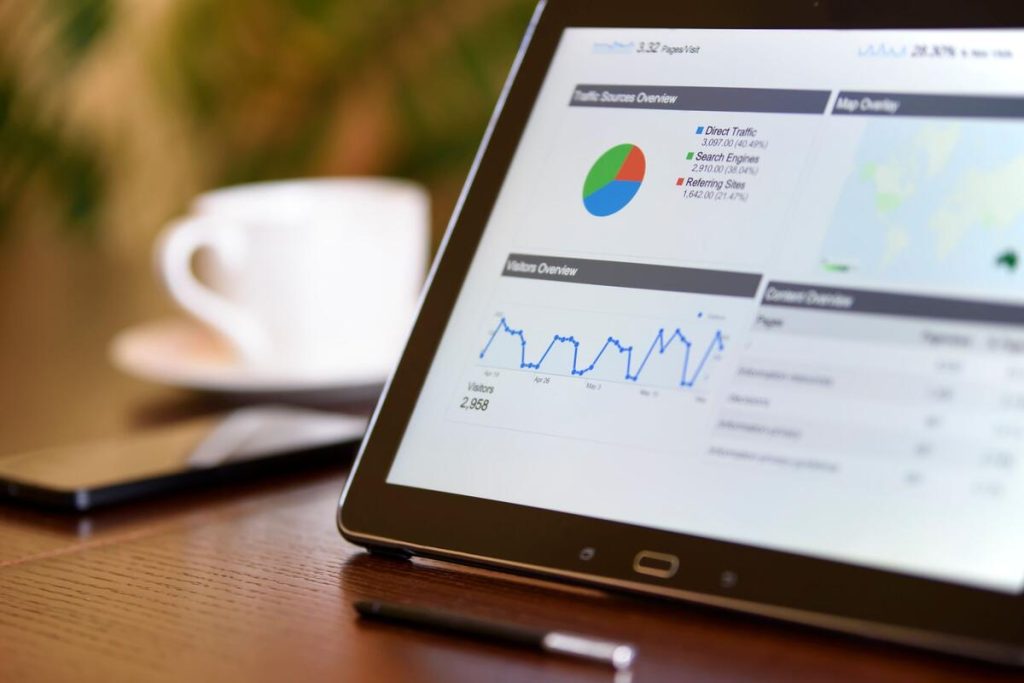 laptop screen showing search engine results page and analytics graph on a desk