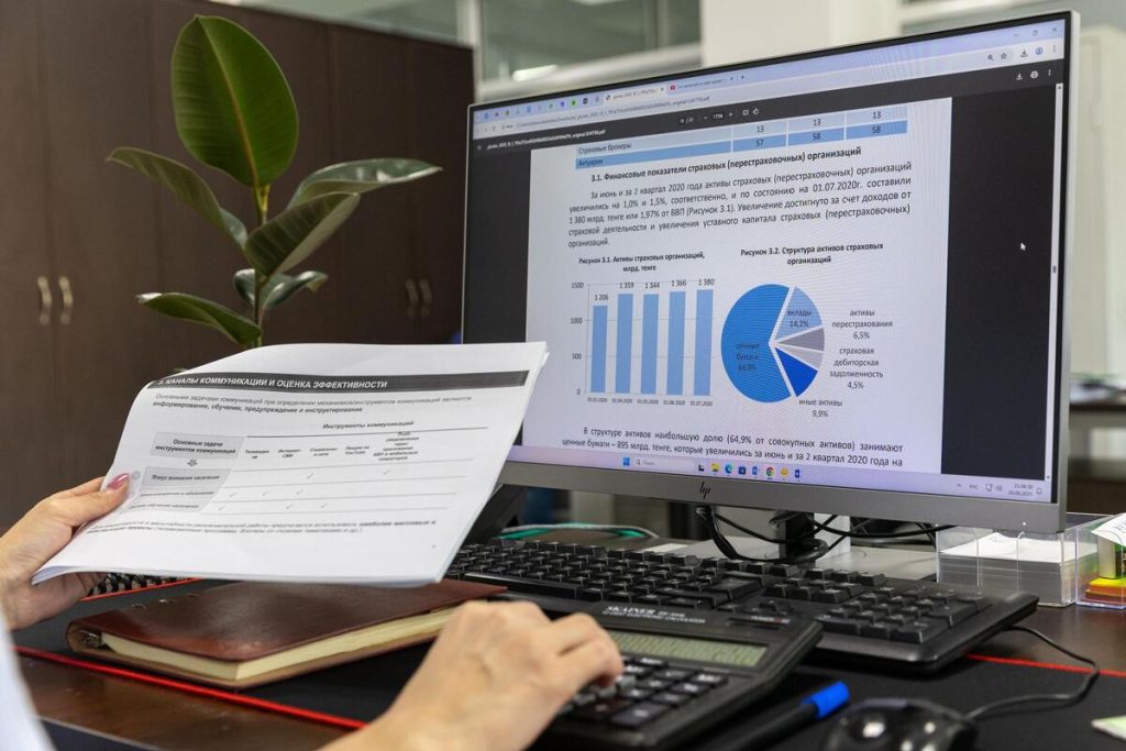 person reviewing website analytics dashboard on a desktop monitor, charts and graphs visible, office desk, no face visible