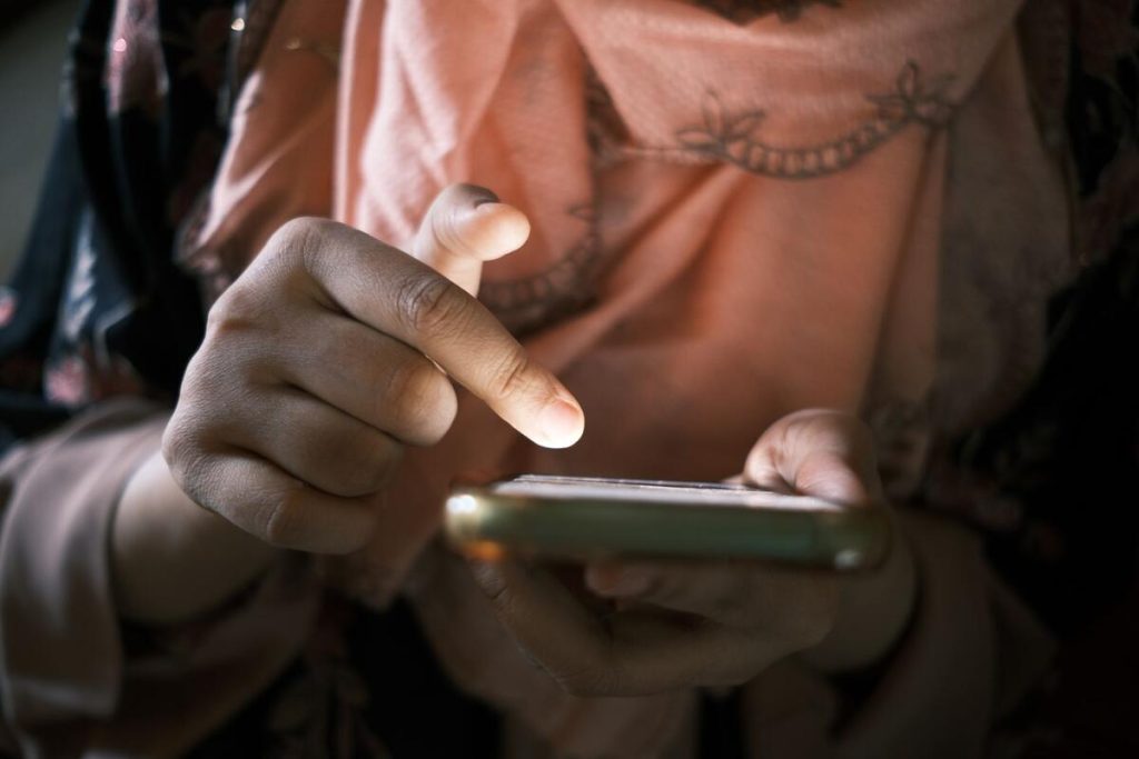 person scrolling news feed on smartphone, hands only