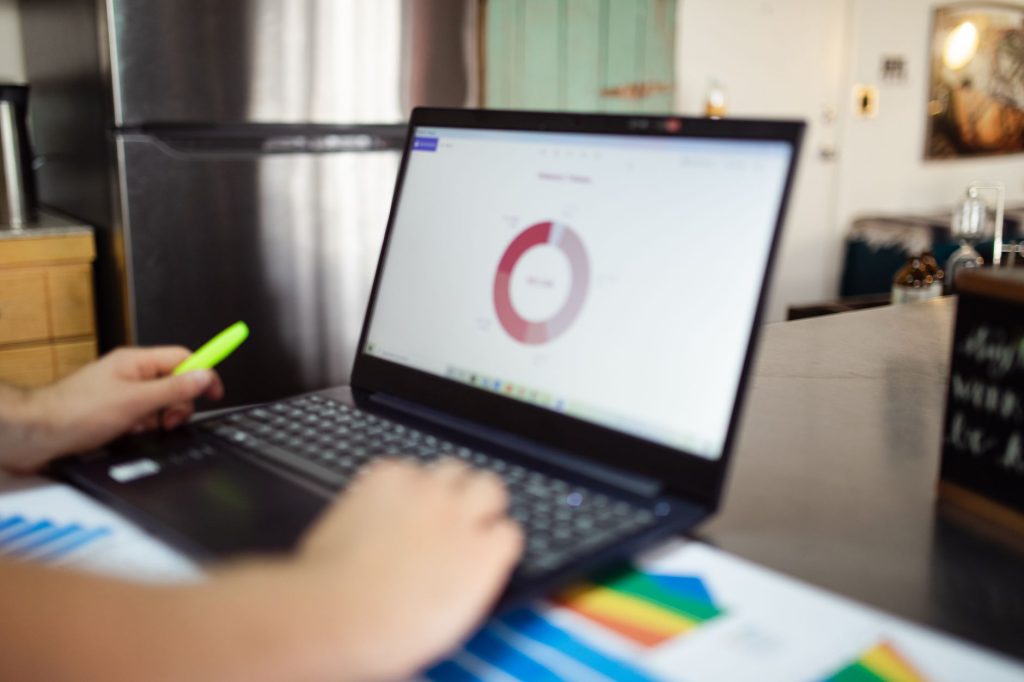 business analytics dashboard glowing on laptop screen at night, office desk, no people