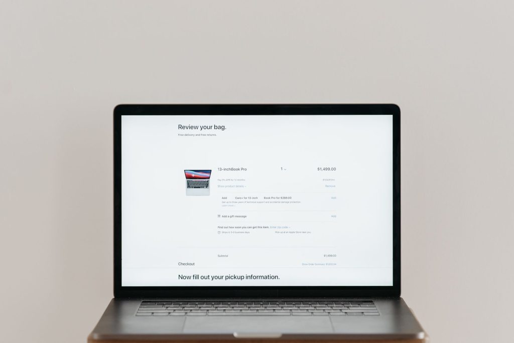 close-up of a laptop screen showing an e-commerce shopping cart and analytics dashboard, no people