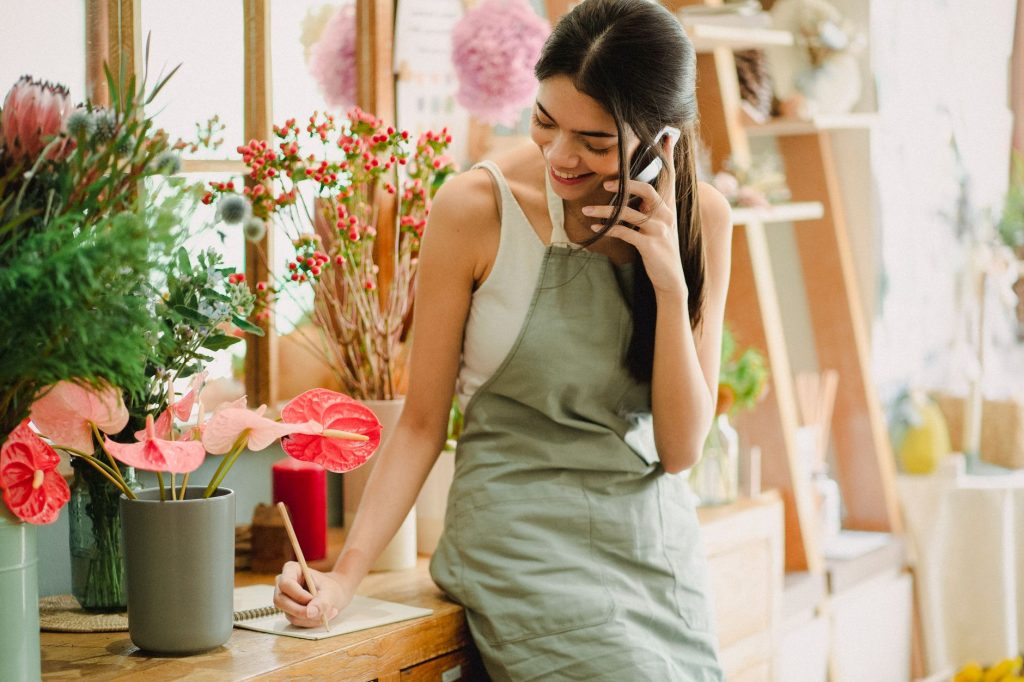 small business owner checking smartphone messages at a shop counter